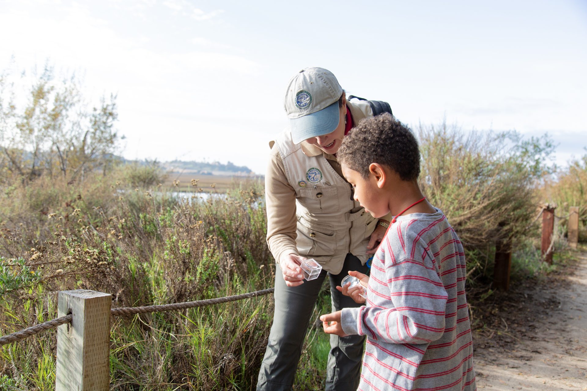 volunteer leader helps young student on field trip at San Elijo Lagoon