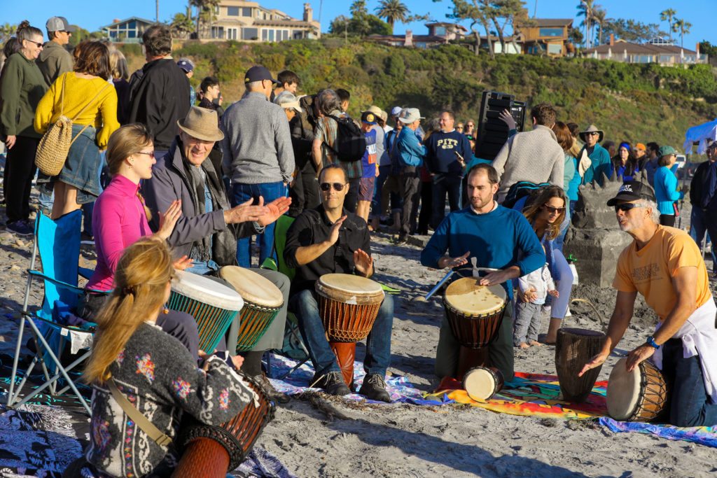 people drumming on beach