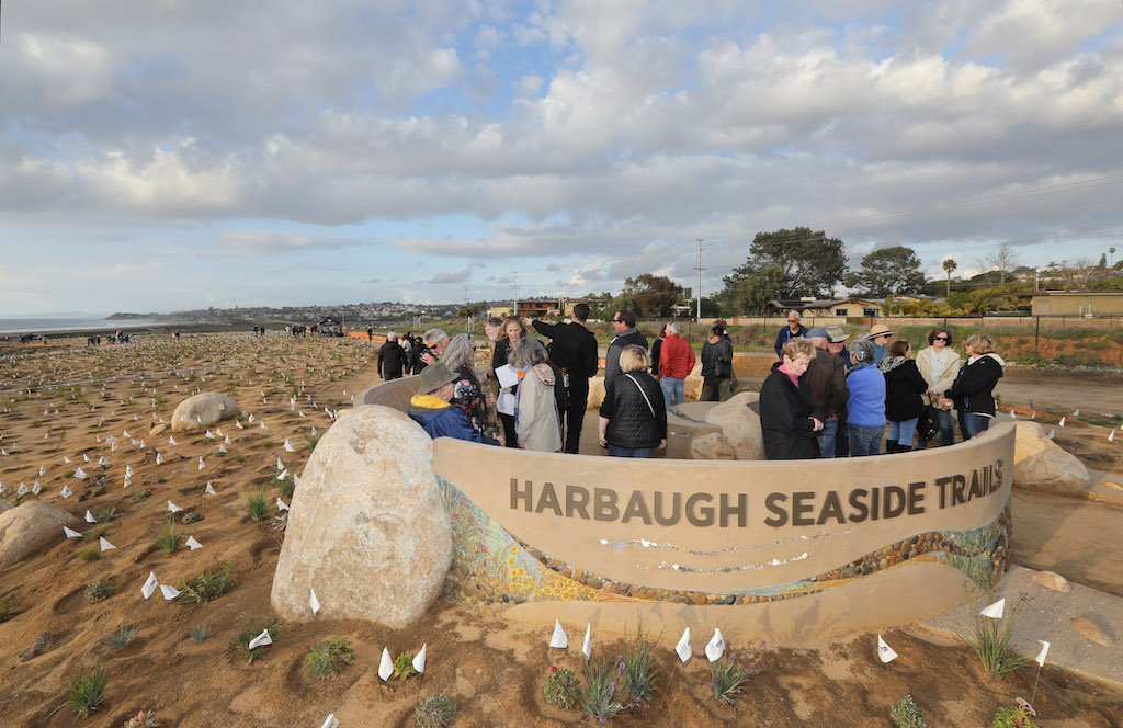 people gather at the donor monument of harbaugh seaside trails