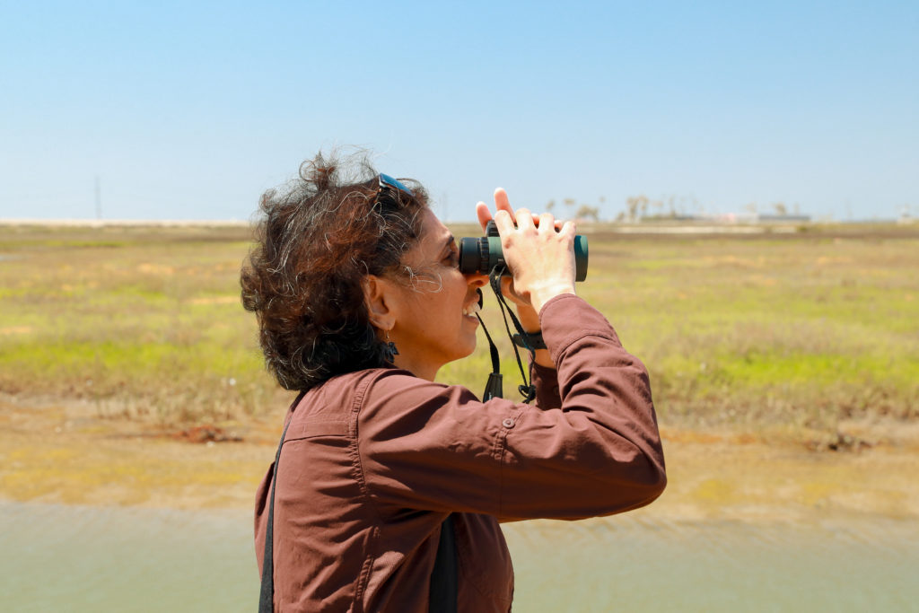 Padma looking at birds with binoculars