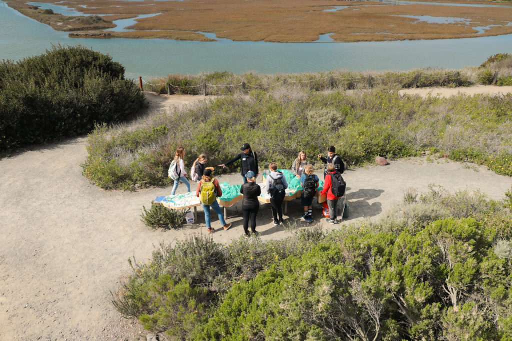 Campers observing the watershed model located at the San Elijo Lagoon Nature Center, which was made possible by the Hans + Margaret Doe Charitable Fund at the San Diego Foundation and artist and Nature Collective Legacy Circle member, Kim MacConnel.